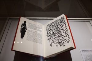 Open display of Thomas Kinsella’s The Táin, with illustration of inky silhouettes by Louis le Brocquy