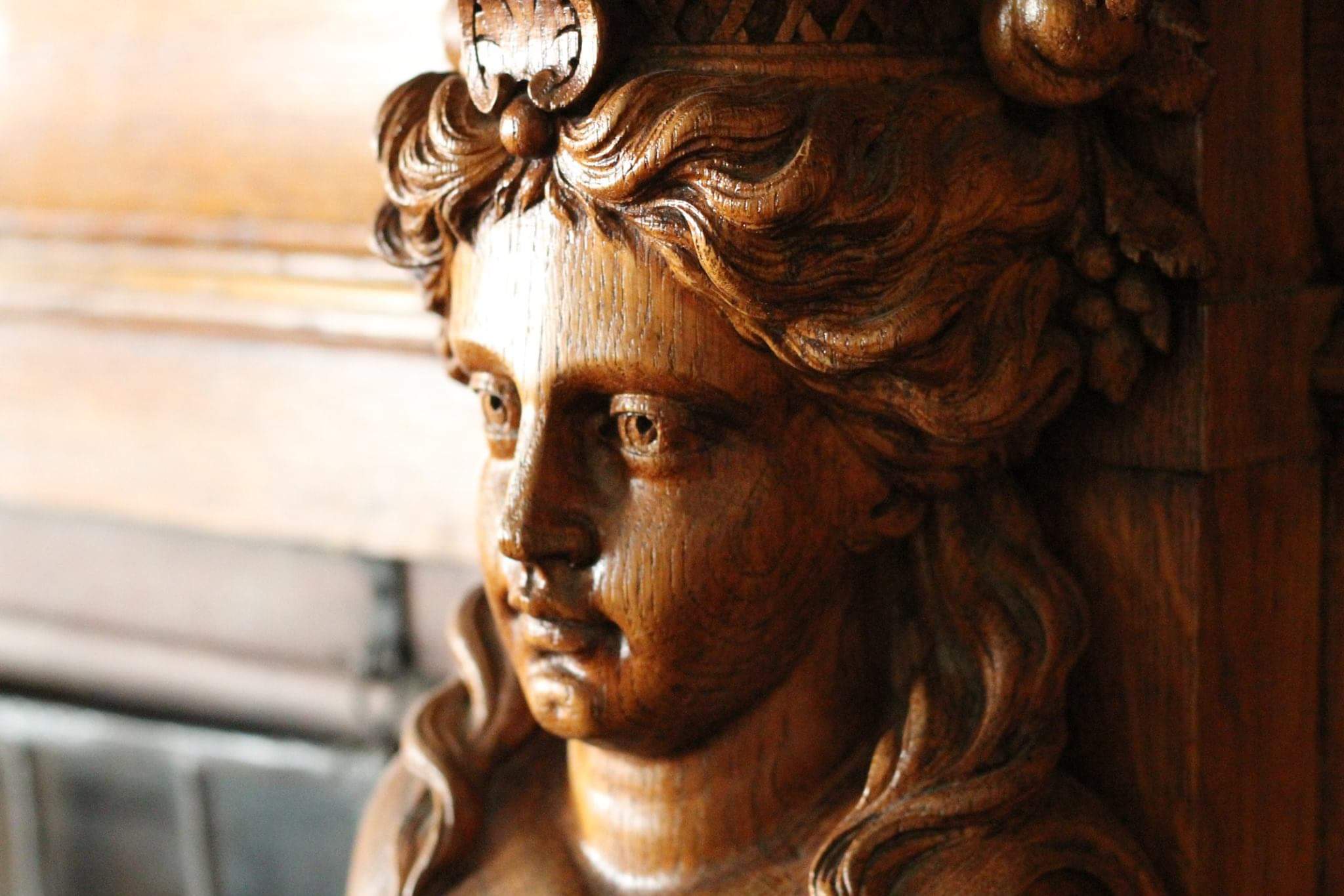 Detail of wood carved face in fireplace