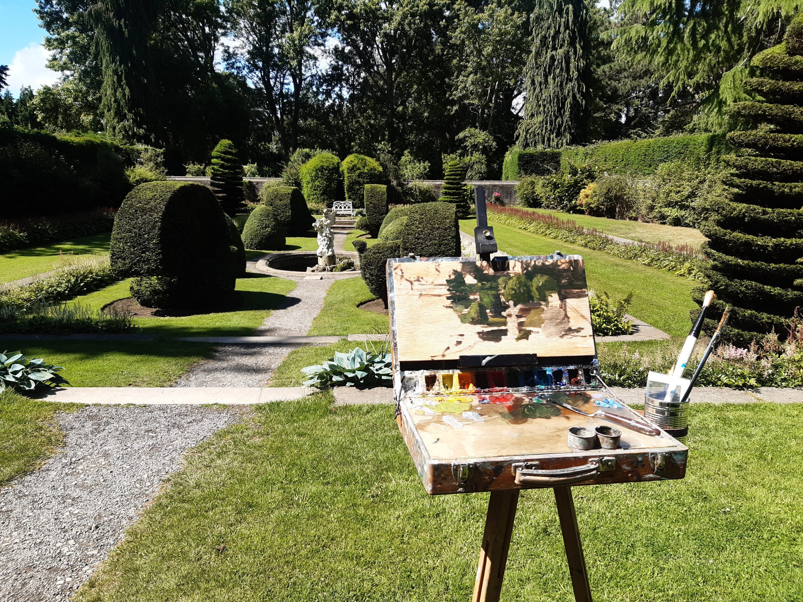 Painting of sunken garden on easel in front of the sunken garden in Farmleigh Estate